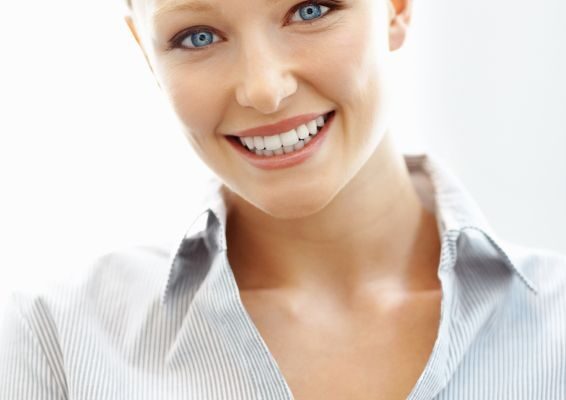 Smiling blonde woman with professionally whitened teeth.